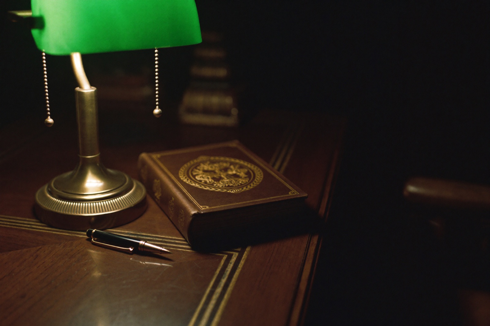 A leather-bound handbook under lamplight