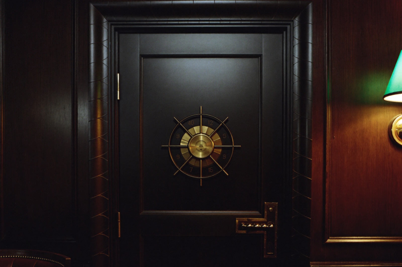 A hidden vault door with a brass combination dial