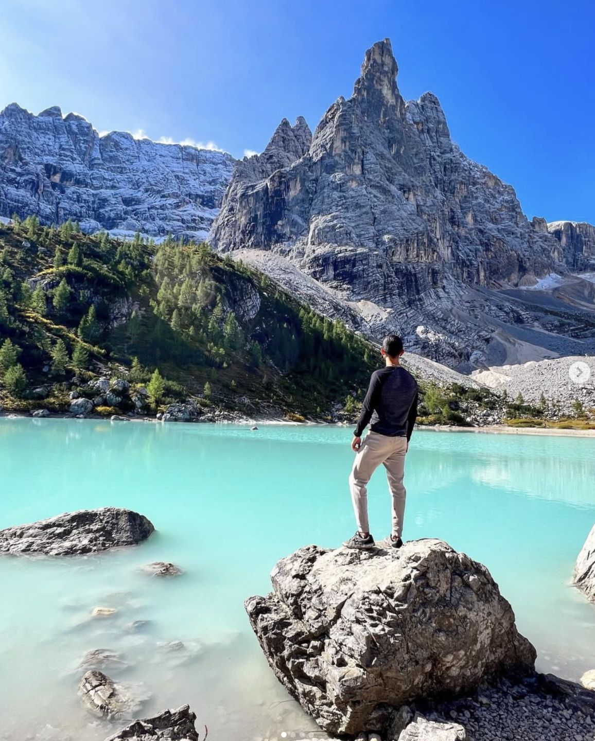 David standing over a turquoise alpine lake in the Dolomites