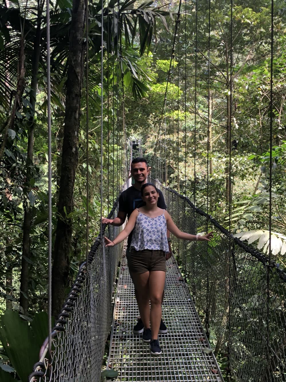 David y Dani cruzando un puente colgante sobre el bosque de Costa Rica