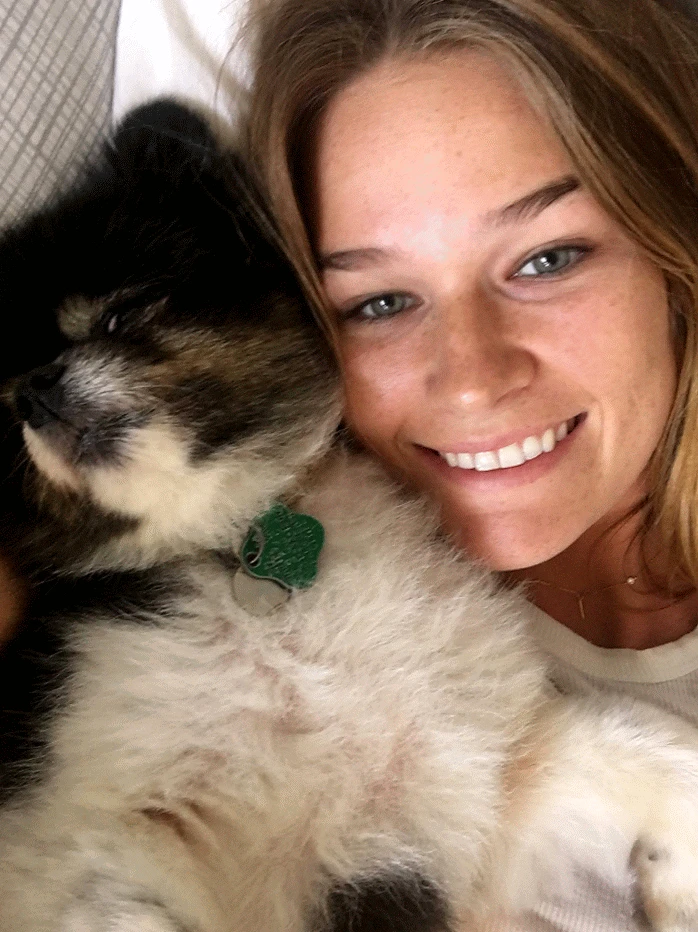 Madeline Taylor Reams smiling cheek to cheek with a sleeping puppy — still, always, the animals too