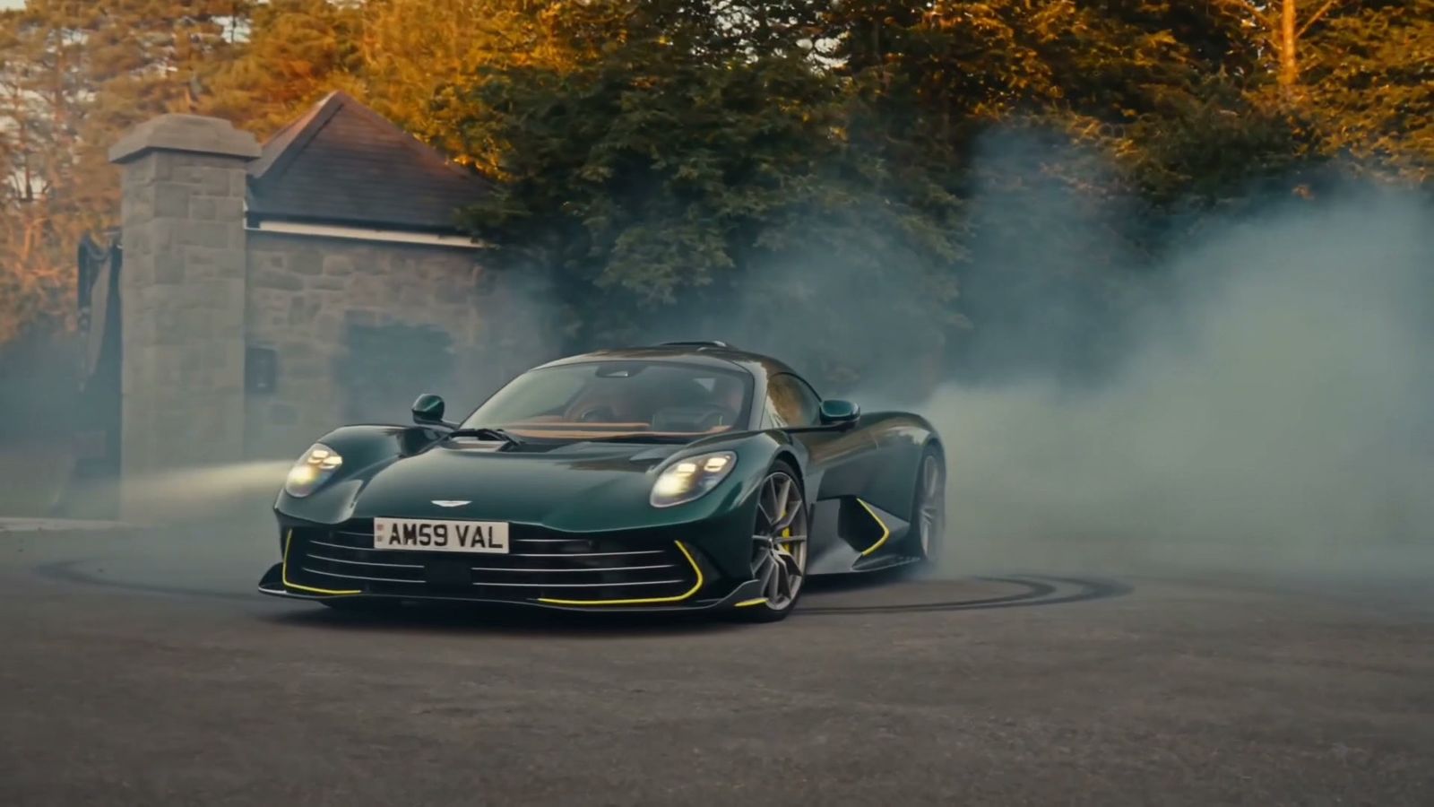 The green Aston Martin spinning smoke at the gatehouse