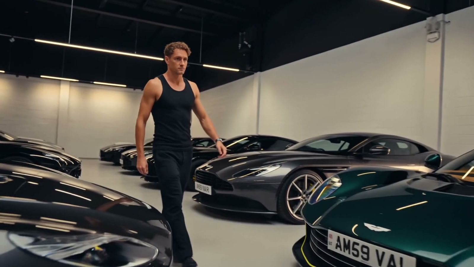 Walking the garage past a line of Aston Martins