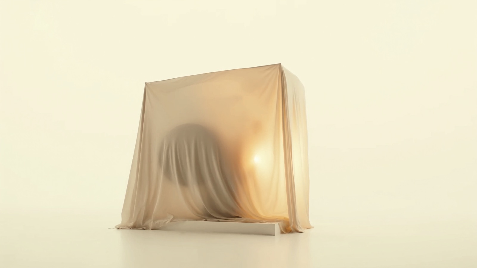 A film projector resting under a tailored grey cover on a plinth in the infinite white studio