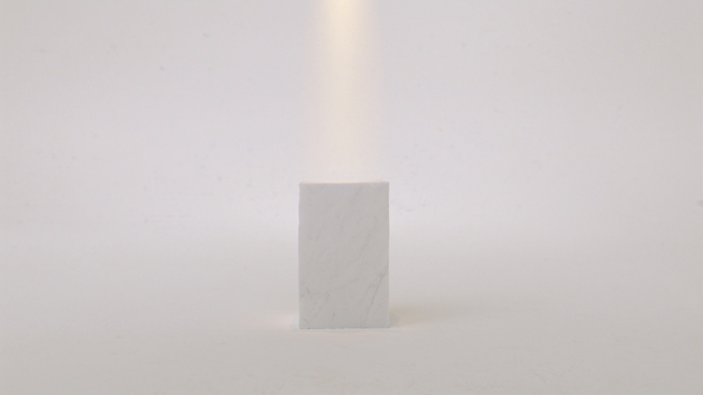 An empty marble plinth under one warm spotlight in the white room, waiting for a product