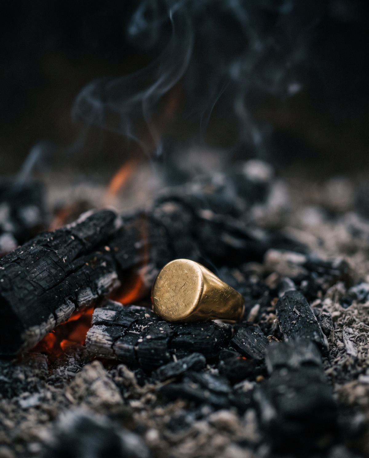 A gold signet ring resting unharmed in glowing embers